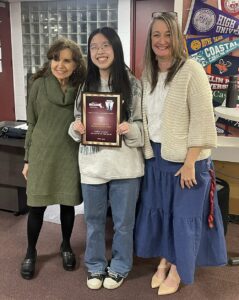 Jennifer Yu, center, poses with National Honors Society Advisors Katherine Doulamis, left, and Jennifer McManus, right, after receiving a plaque acknowledging her as the MSAA's North Region Student of the Year.