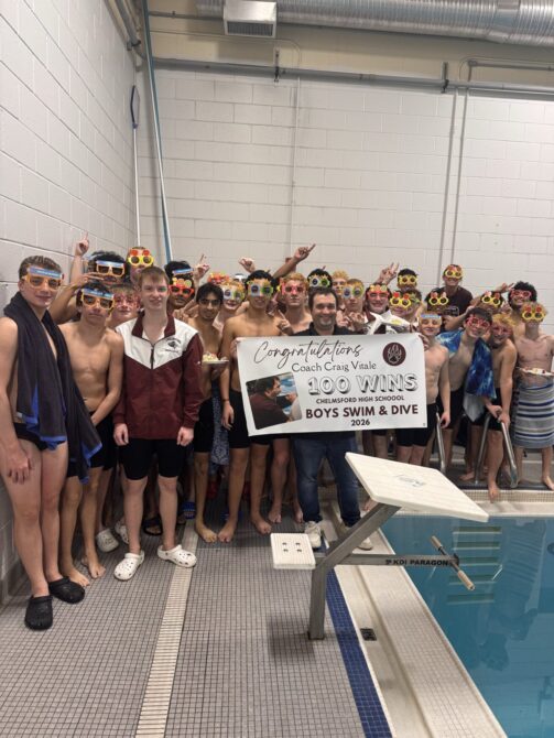 Chelmsford High boys swimming and diving coach Craig Vitale celebrates his 100th career win with his team.