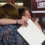 School Committee vice chair Susan Mackinnon receives a hug from her former student Elizabeth Dunlea, a senior who is planning to study secondary education at Bridgewater State University.