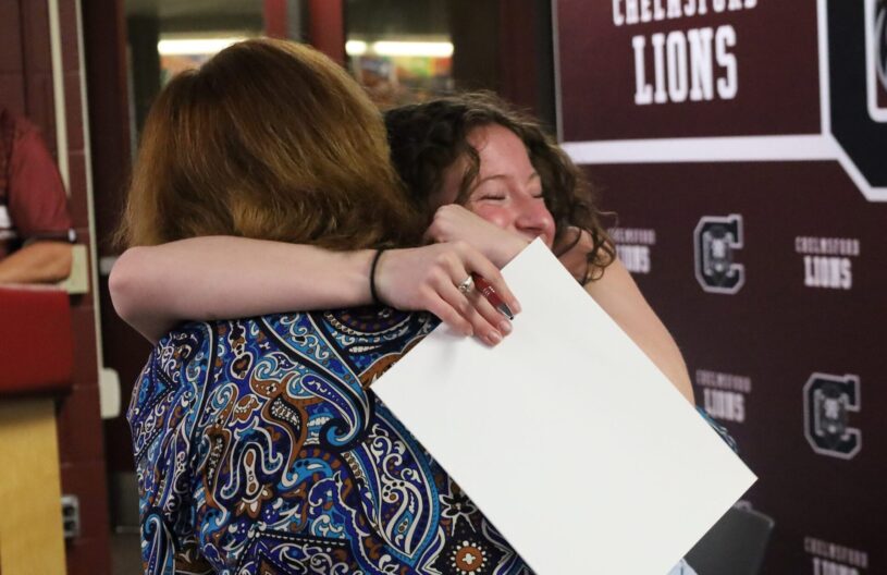 School Committee vice chair Susan Mackinnon receives a hug from her former student Elizabeth Dunlea, a senior who is planning to study secondary education at Bridgewater State University.
