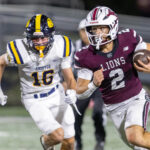 Chelmsford quarterback Skyler DeJesus gets past Andover’s Adrian Penney to pick up a first down during Friday’s MVC football game at Simonian Stadium in Chelmsford.