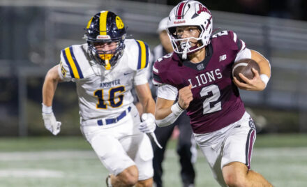Chelmsford quarterback Skyler DeJesus gets past Andover’s Adrian Penney to pick up a first down during Friday’s MVC football game at Simonian Stadium in Chelmsford.
