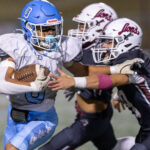 Dracut’s Phillip Dinh carries for a short gain before being tackled by Chelmsford defenders Aidan O’Donnell and Josh Valdez during Thursday’s MVC football game at Simonian Field in Chelmsford. Chelmsford captured a 25-0 win.