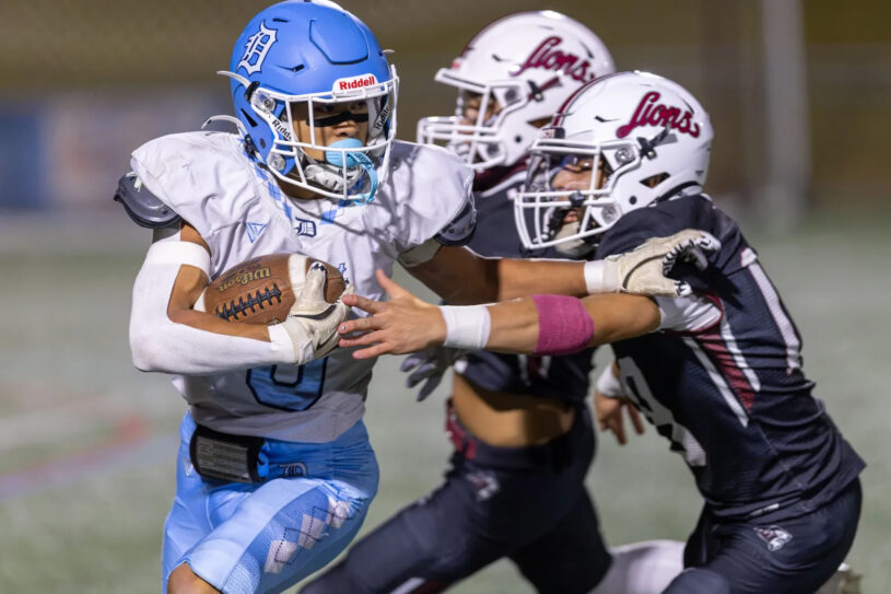 Dracut’s Phillip Dinh carries for a short gain before being tackled by Chelmsford defenders Aidan O’Donnell and Josh Valdez during Thursday’s MVC football game at Simonian Field in Chelmsford. Chelmsford captured a 25-0 win.